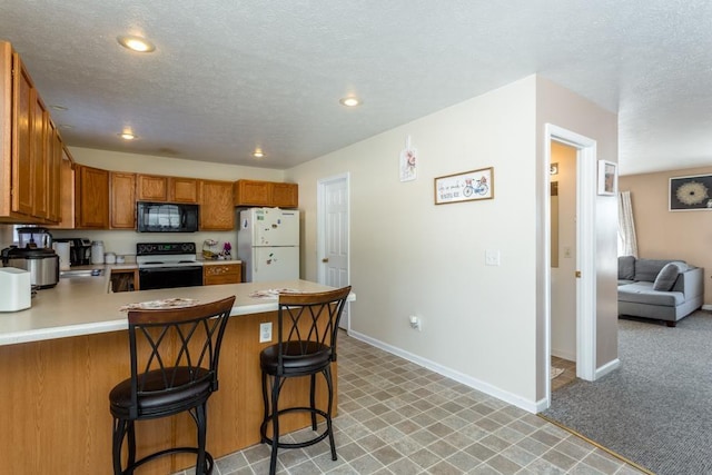 kitchen featuring a breakfast bar, black appliances, kitchen peninsula, light carpet, and a textured ceiling