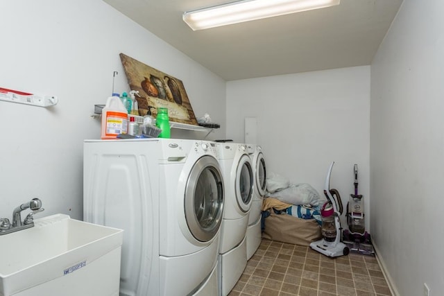 clothes washing area featuring sink and washer and dryer