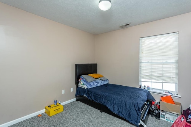 carpeted bedroom featuring a textured ceiling