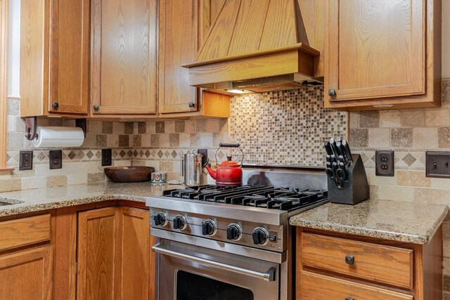 4201 Brown Mountain Ln, Elkton, VA 22827 - kitchen featuring high end stainless steel range, custom range hood, backsplash, light stone countertops, and brown cabinetry