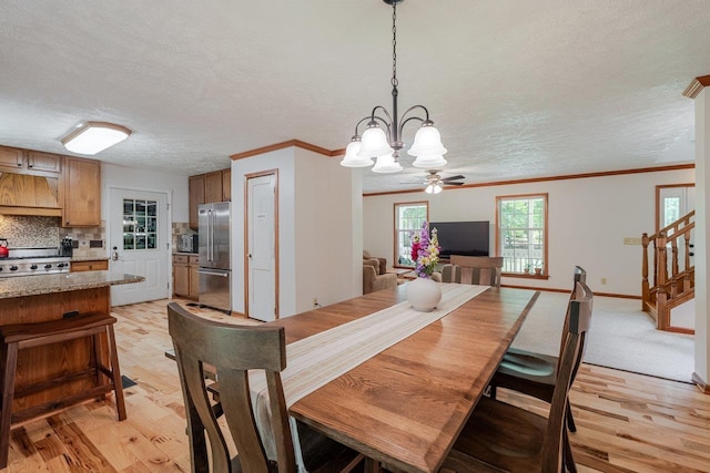 4201 Brown Mountain Ln, Elkton, VA 22827 - dining area with a chandelier, a textured ceiling, light wood-style floors, crown molding, and stairs
