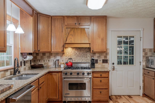 4201 Brown Mountain Ln, Elkton, VA 22827 - kitchen with stainless steel appliances, custom range hood, brown cabinetry, backsplash, and light stone counters
