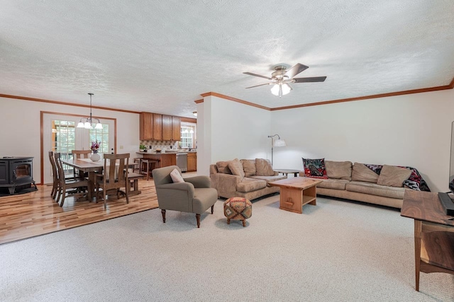 4201 Brown Mountain Ln, Elkton, VA 22827 - living room with light carpet, a wood stove, ceiling fan, crown molding, and a textured ceiling