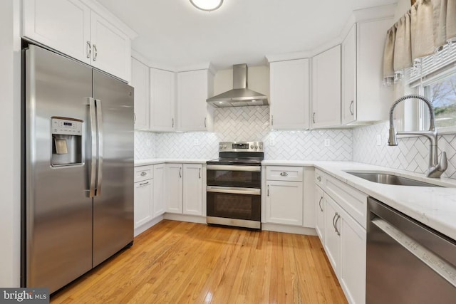 12011 Big Ben Blvd, Fredericksburg, VA 22407 - kitchen featuring appliances with stainless steel finishes, wall chimney exhaust hood, a sink, light countertops, and light wood-style floors