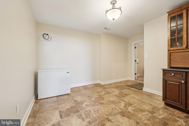 12011 Big Ben Blvd, Fredericksburg, VA 22407 - unfurnished dining area with light stone finish flooring and baseboards