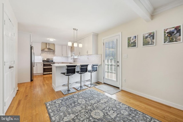 12011 Big Ben Blvd, Fredericksburg, VA 22407 - kitchen with appliances with stainless steel finishes, a peninsula, light wood-style floors, decorative backsplash, and wall chimney range hood
