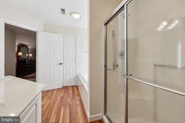 12011 Big Ben Blvd, Fredericksburg, VA 22407 - bathroom with wood finished floors, a shower stall, vanity, and a garden tub