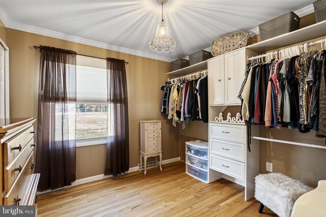 spacious closet with a notable chandelier and light wood-type flooring