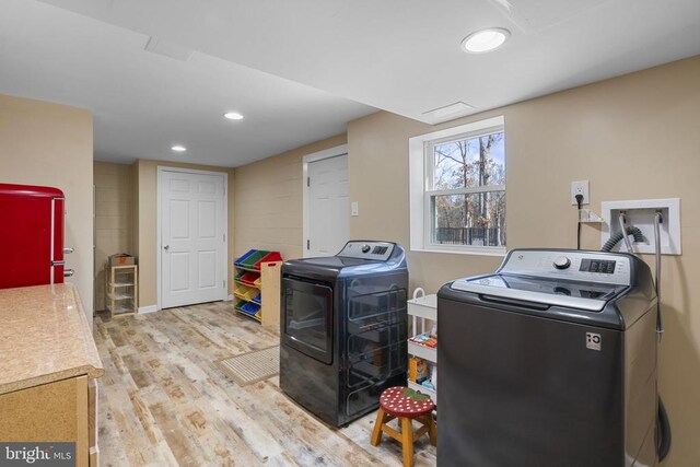 laundry area with light hardwood / wood-style flooring and independent washer and dryer