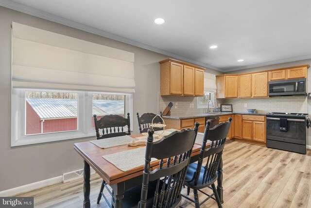 dining area featuring sink, light hardwood / wood-style flooring, and ornamental molding