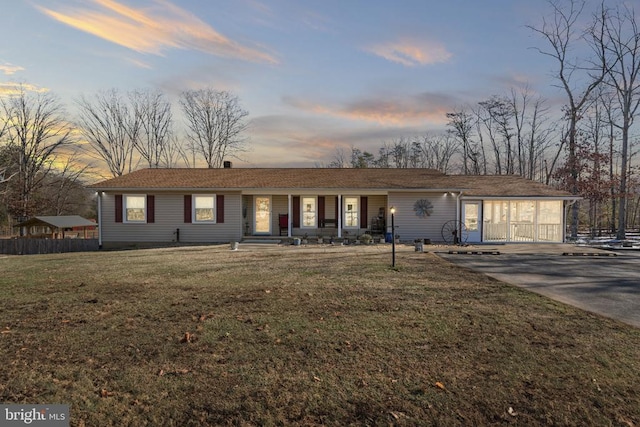 single story home with a porch and a yard