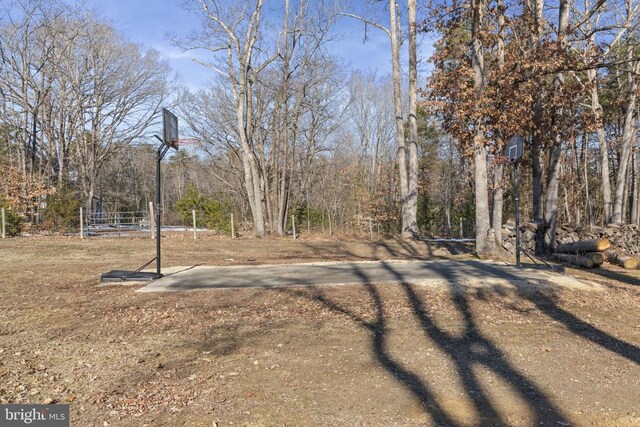 view of yard featuring basketball hoop