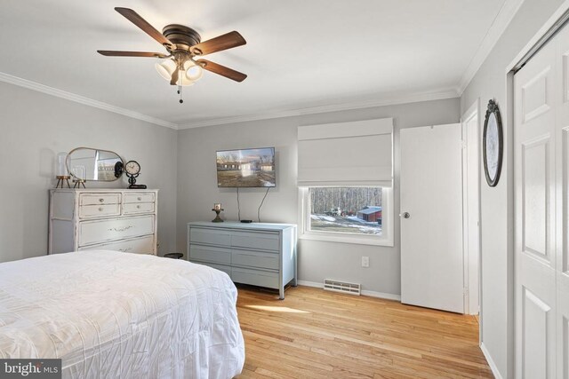 bedroom with crown molding, light hardwood / wood-style flooring, and ceiling fan