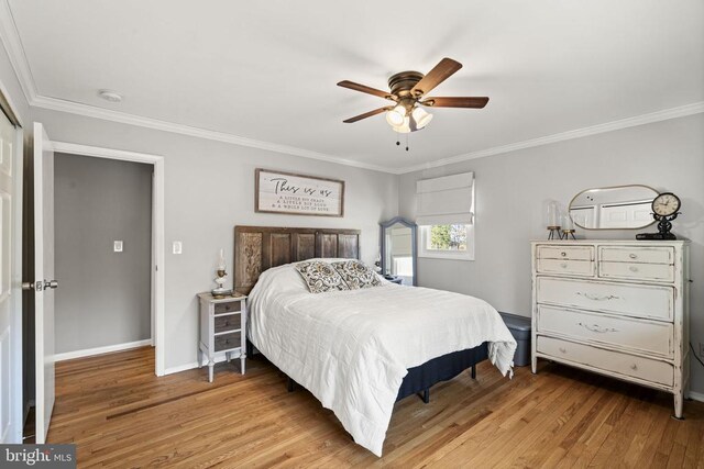 bedroom with hardwood / wood-style flooring, ceiling fan, and crown molding