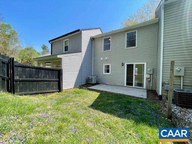 back of property featuring a lawn, central air condition unit, a patio, and fence