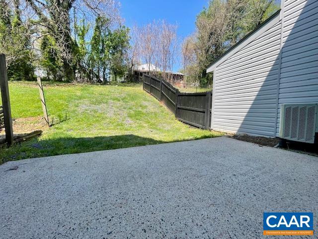 view of yard featuring central AC, a patio area, and fence