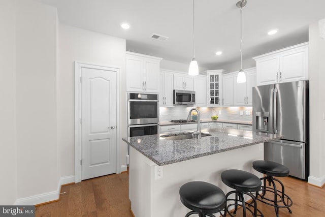 6104 New Berne Rd, Fredericksburg, VA 22407 - kitchen with stainless steel appliances, wood finished floors, white cabinetry, stone countertops, and tasteful backsplash