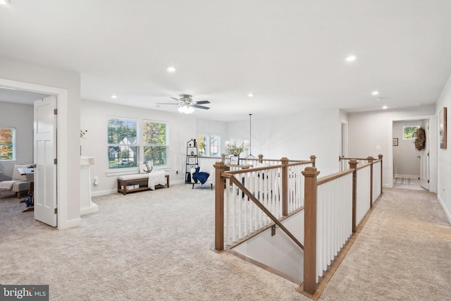 hallway with an upstairs landing, light colored carpet, recessed lighting, baseboards, and a chandelier