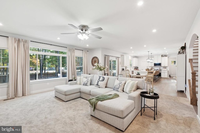 living room featuring recessed lighting, ceiling fan, baseboards, and light carpet