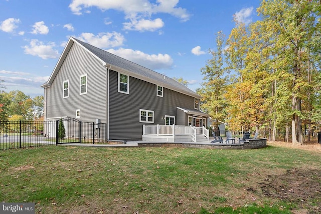 back of house featuring a wooden deck, a gate, and a patio
