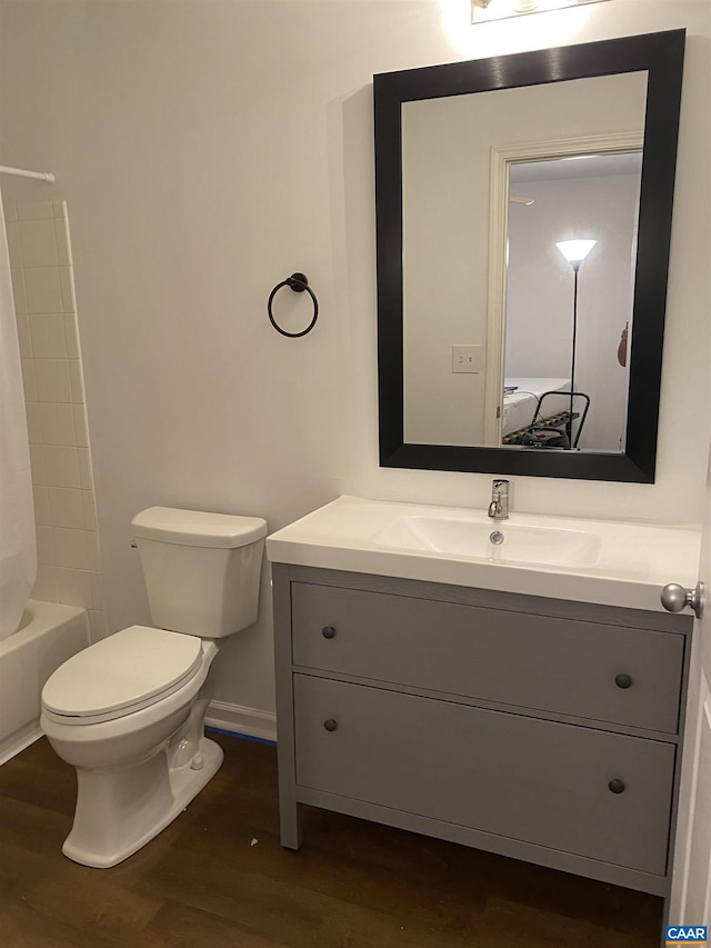 bathroom with toilet, baseboards, vanity, and wood finished floors