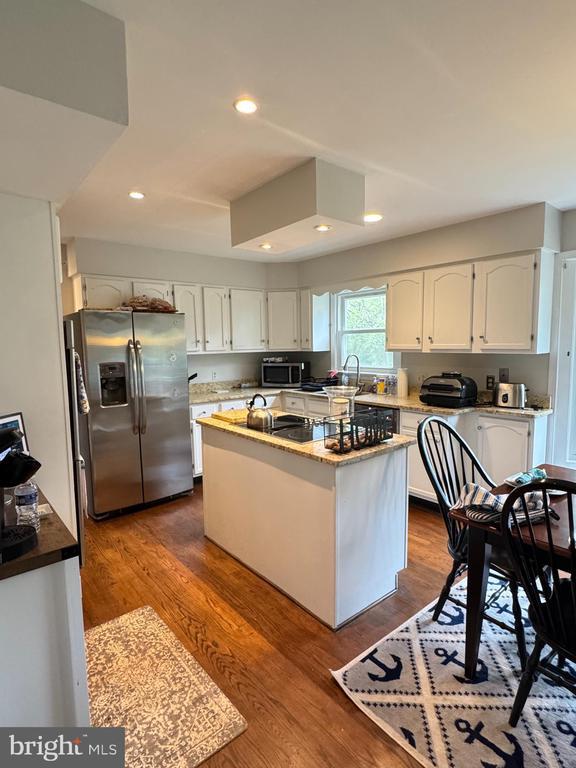 7880 Sir Topas Dr, Warrenton, VA 20186 - kitchen with stainless steel appliances, white cabinetry, dark wood finished floors, recessed lighting, and a sink