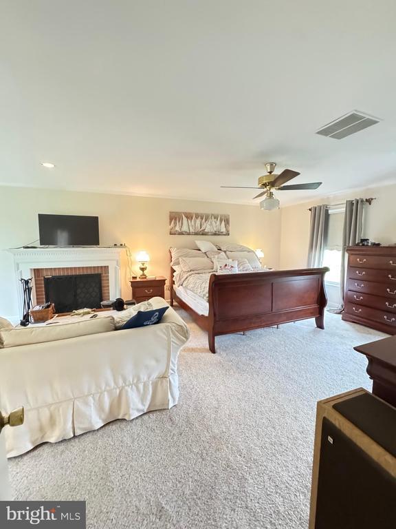 7880 Sir Topas Dr, Warrenton, VA 20186 - carpeted bedroom with ceiling fan and a brick fireplace