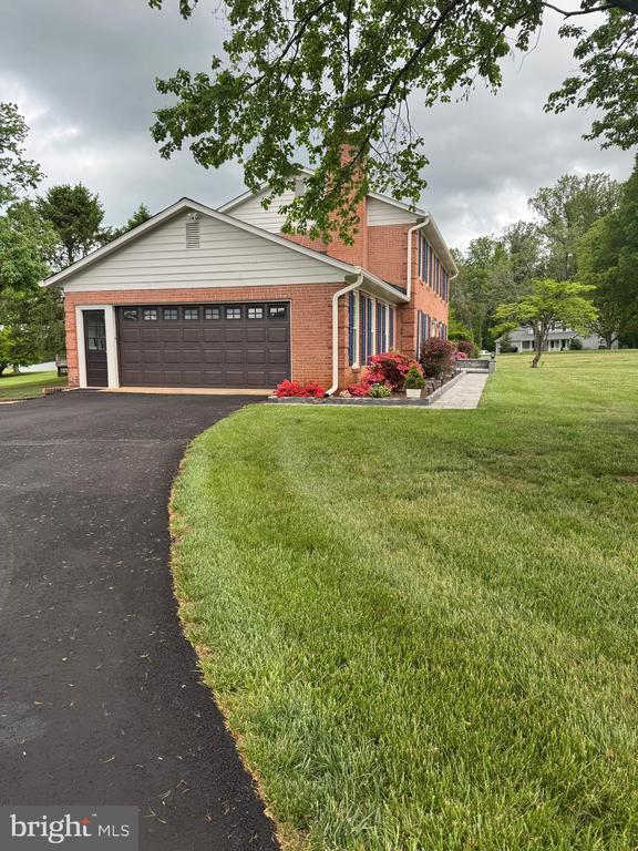 7880 Sir Topas Dr, Warrenton, VA 20186 - view of front of house with brick siding, a front yard, an attached garage, and asphalt driveway