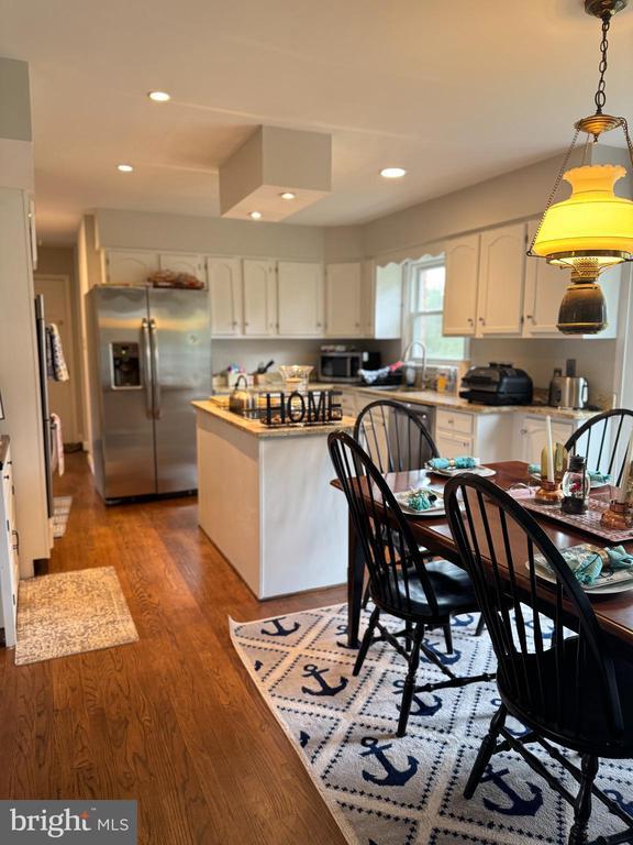 7880 Sir Topas Dr, Warrenton, VA 20186 - kitchen with appliances with stainless steel finishes, white cabinetry, recessed lighting, light wood-style flooring, and hanging light fixtures