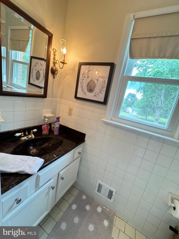 7880 Sir Topas Dr, Warrenton, VA 20186 - bathroom with tile walls, vanity, tile patterned flooring, and a wainscoted wall