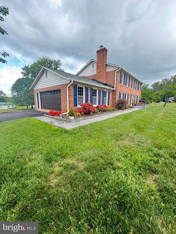 7880 Sir Topas Dr, Warrenton, VA 20186 - colonial inspired home with brick siding, a chimney, an attached garage, and a front yard