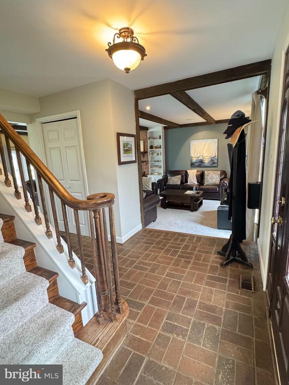 7880 Sir Topas Dr, Warrenton, VA 20186 - entryway featuring brick flooring, baseboards, and stairway