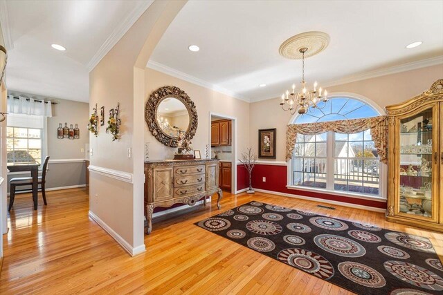 102 Shawn Cir, Staunton, VA 24401 - interior space featuring ornamental molding, baseboards, light wood-style flooring, arched walkways, and a notable chandelier