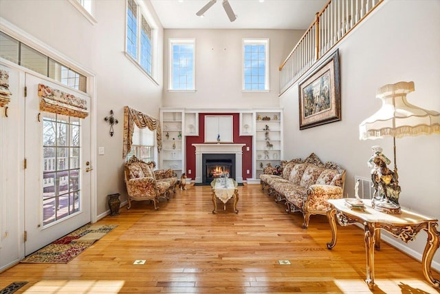 102 Shawn Cir, Staunton, VA 24401 - living room with a ceiling fan, visible vents, wood-type flooring, a lit fireplace, and a high ceiling