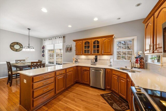 102 Shawn Cir, Staunton, VA 24401 - kitchen with light wood-style flooring, a sink, a peninsula, brown cabinets, and appliances with stainless steel finishes