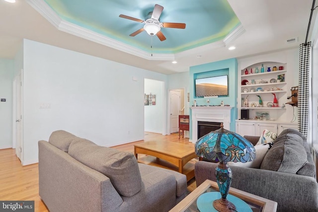 514 Lakeview Pkwy, Locust Grove, VA 22508 - living room featuring a tray ceiling, crown molding, a ceiling fan, light wood-style flooring, and a fireplace