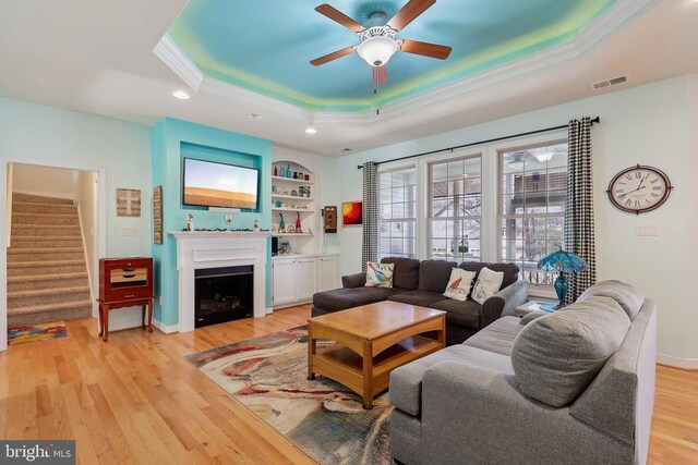 514 Lakeview Pkwy, Locust Grove, VA 22508 - living room with a tray ceiling, a ceiling fan, stairway, ornamental molding, and light wood finished floors