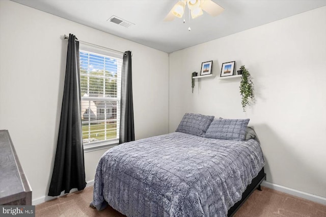 carpeted bedroom featuring visible vents, a ceiling fan, and baseboards