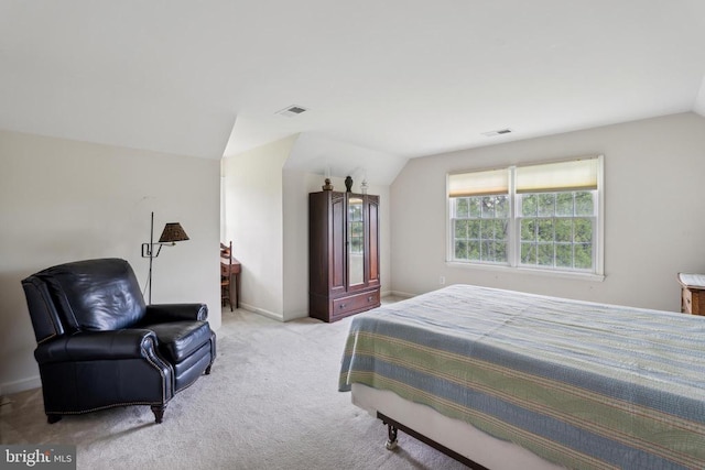 bedroom with lofted ceiling, light colored carpet, and baseboards