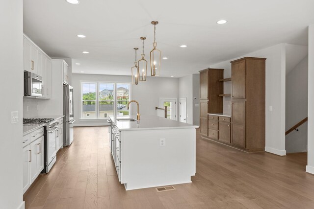 3251 Preston Shore Dr Unit 18E, Rockingham, VA 22801 - kitchen featuring stainless steel appliances, a sink, open shelves, recessed lighting, and a center island with sink