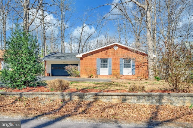 view of front of home featuring a garage, driveway, and brick siding