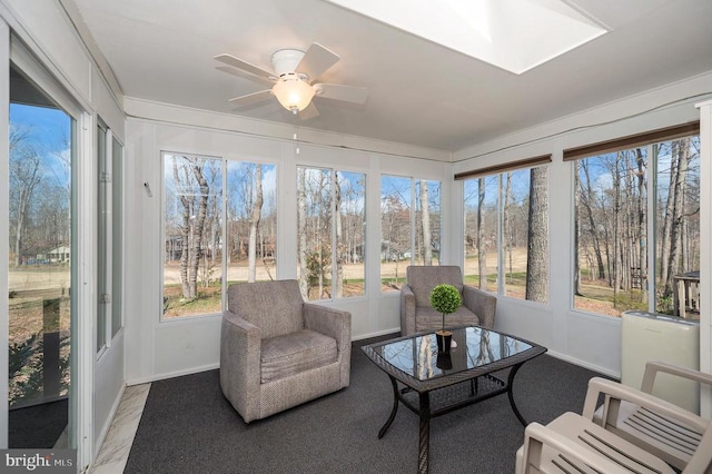 sunroom featuring baseboards and a skylight