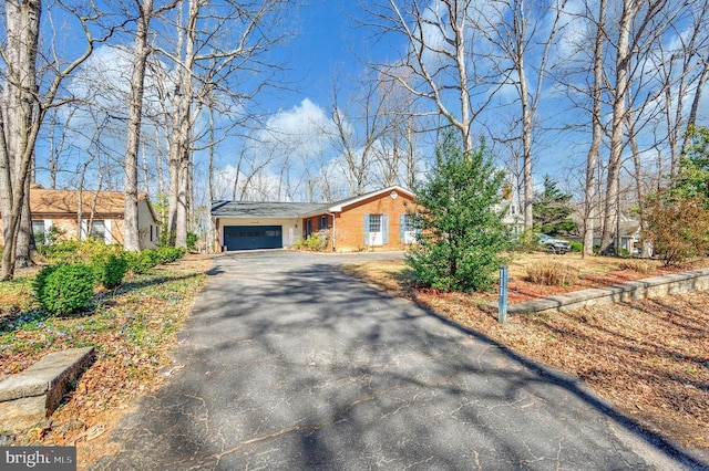 view of front facade with driveway, an attached garage, and brick siding