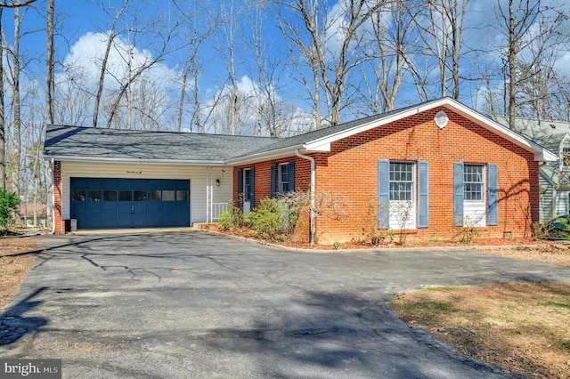 single story home with asphalt driveway, brick siding, and a garage