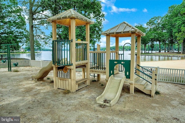community jungle gym featuring a water view and fence