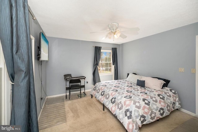 bedroom featuring light carpet, baseboards, and ceiling fan