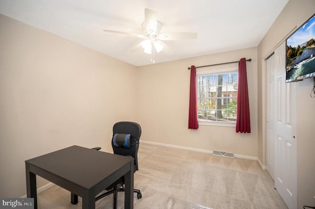 office area featuring ceiling fan, baseboards, and light carpet
