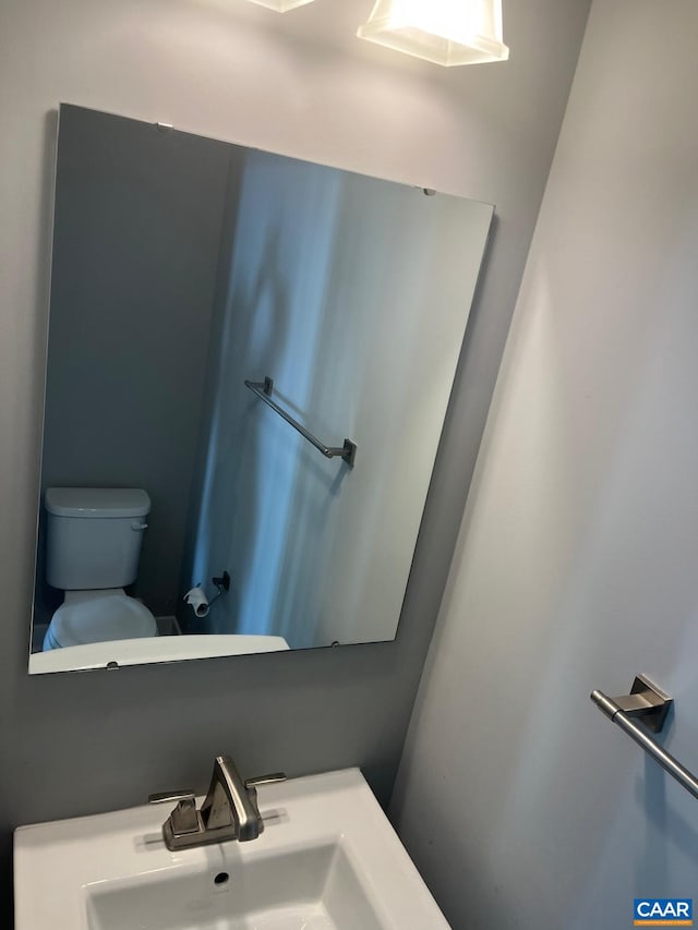 half bath with toilet and a sink