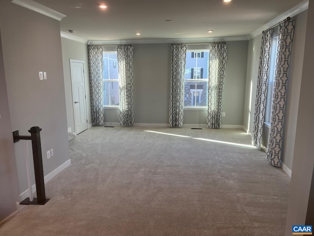 carpeted empty room with crown molding, baseboards, and recessed lighting