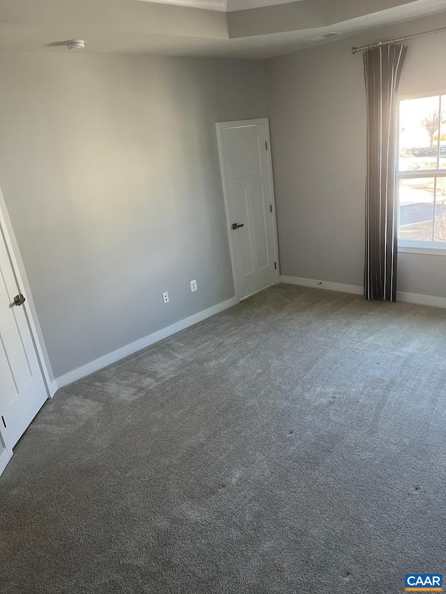 empty room featuring carpet floors and baseboards